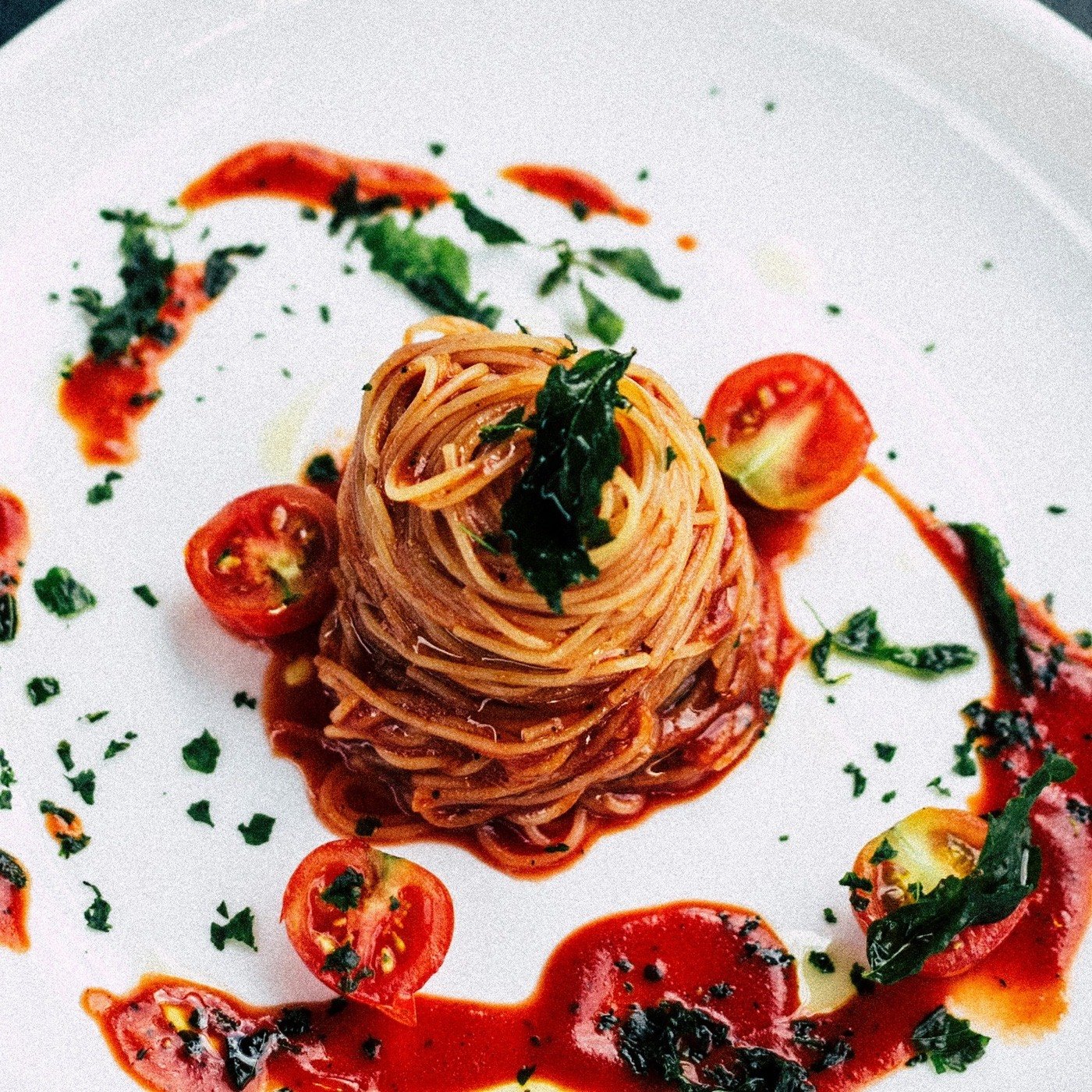 Plato de spaghetti con salsa de tomate, tomates cherry y albahaca