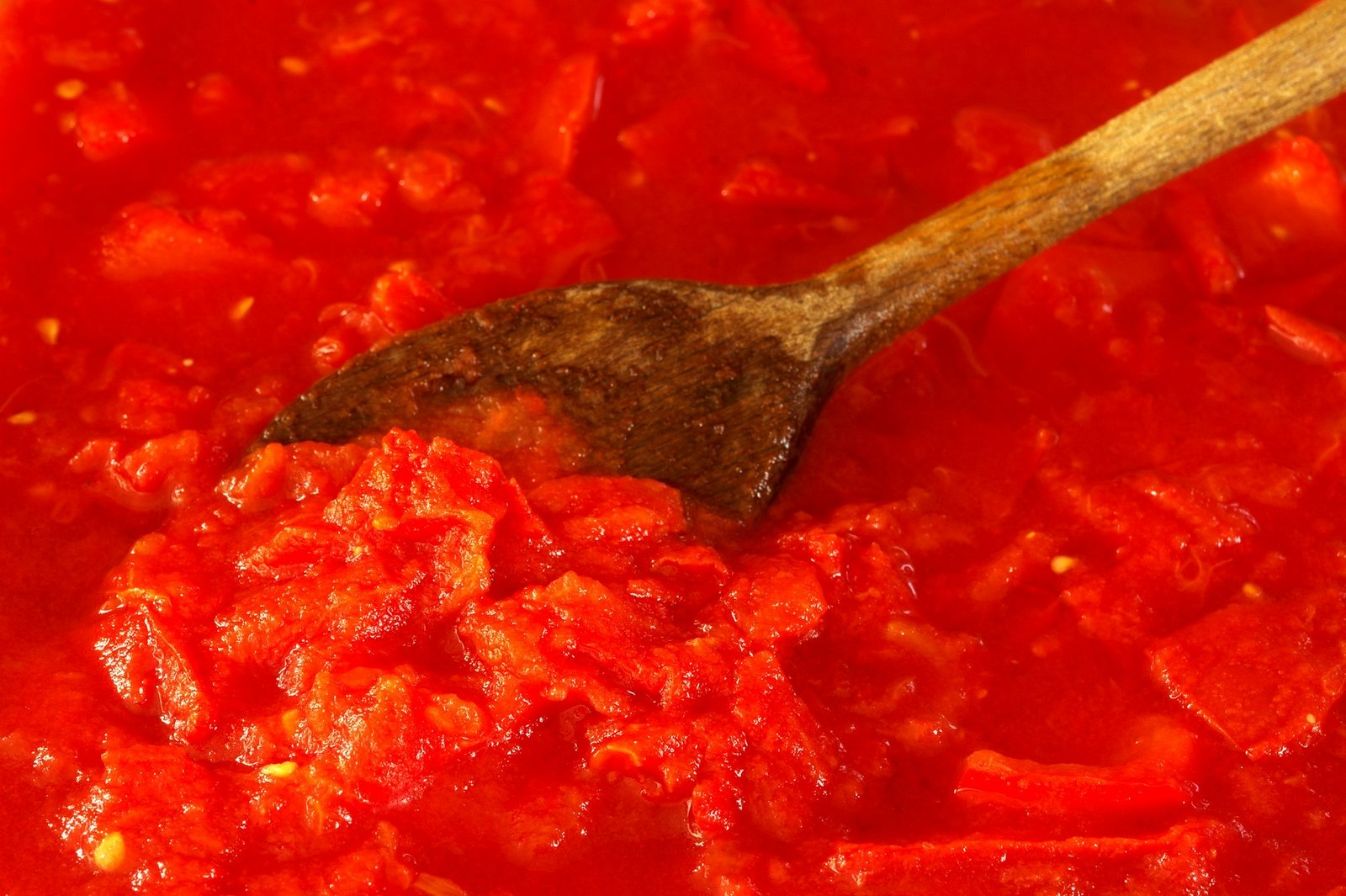 Salsa de tomate casera con una cuchara de madera