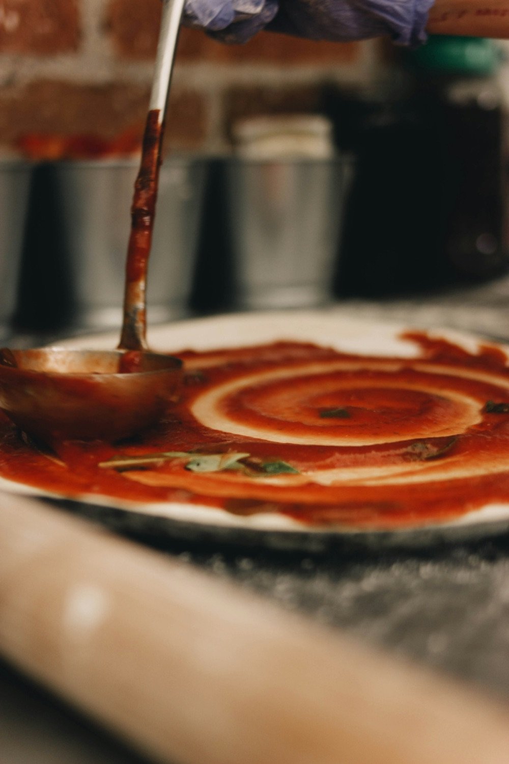 Salsa de tomate extendida en espiral con un cucharón