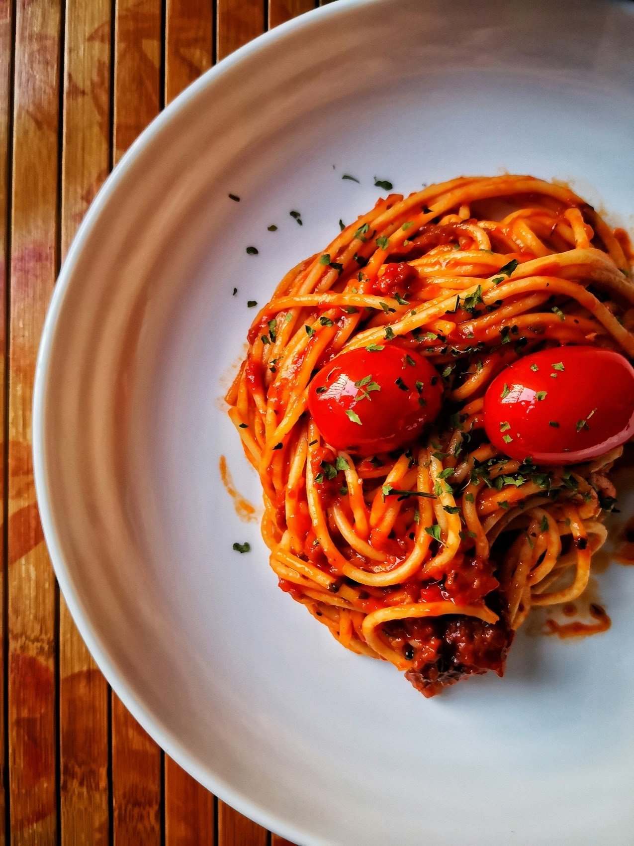 Spaghetti con salsa de tomate y tomates cherry en un plato blanco
